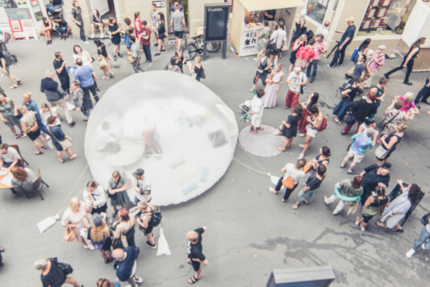 Eine transparente Bubble steht auf einem Platz mit vielen Menschen