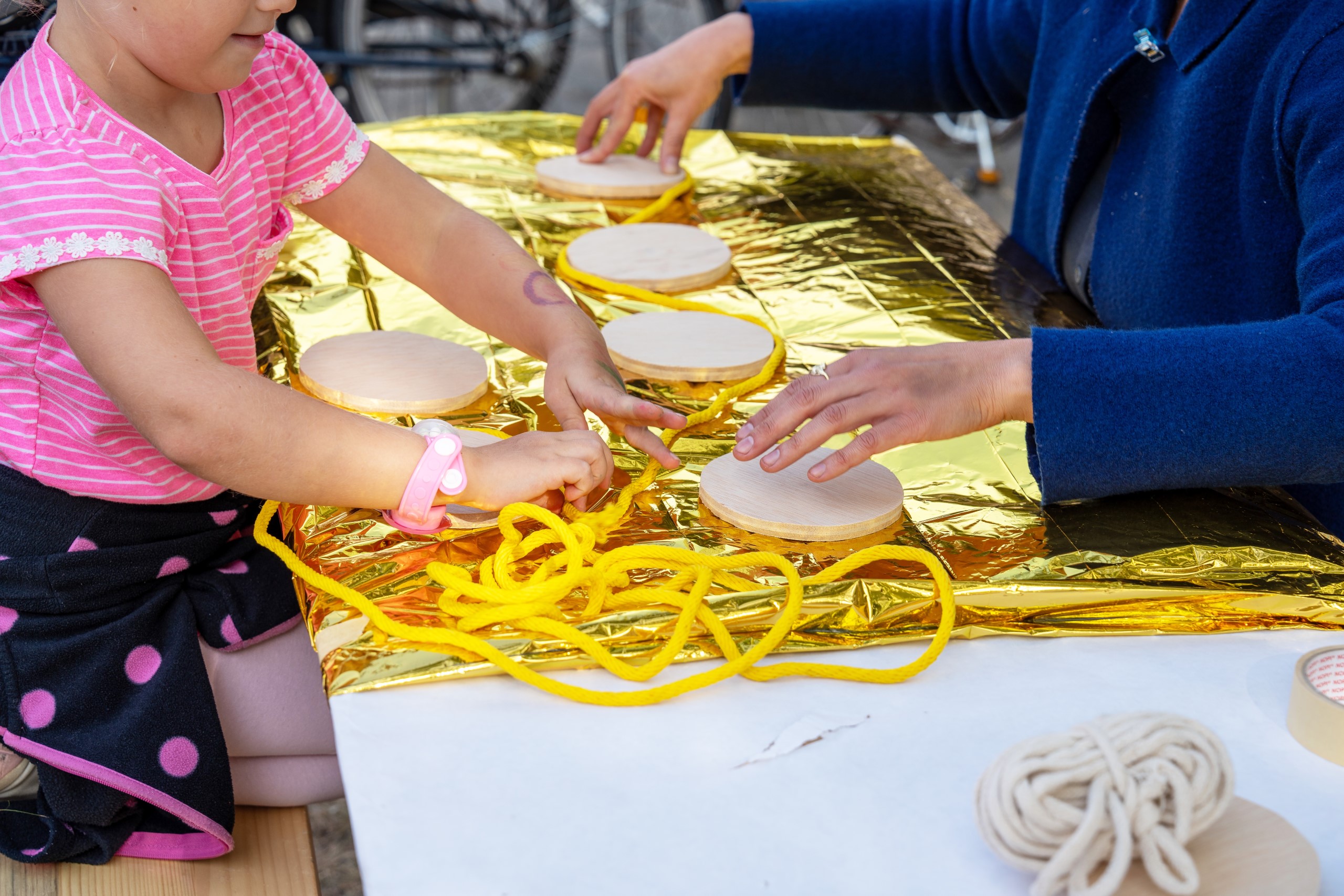 Workshopsituation, bei der Kinder und Jugendliche aufblasbare Strukturen aus goldenen Notfalldecken bauen