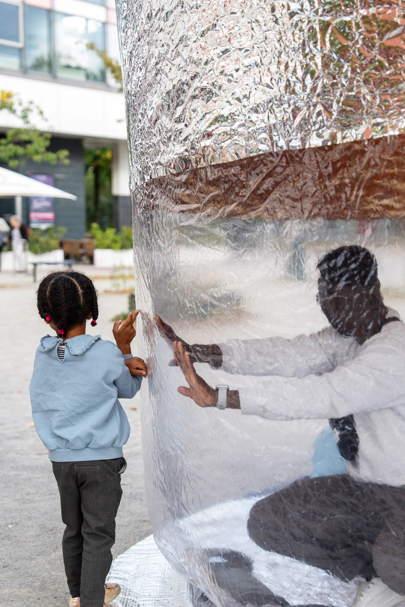 Besucher:innen in der konischen aufblasbaren Installation von Popticum mit unterem transparenten und oben silbernen Teil