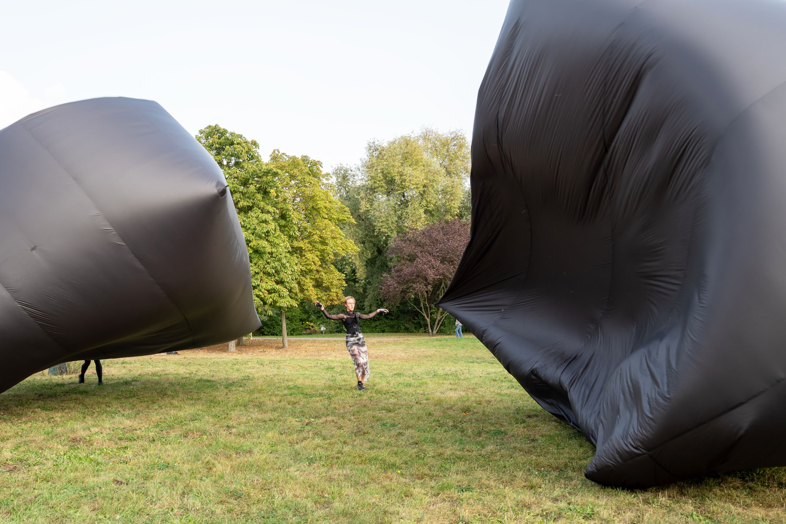 Performance von Renae Shadler & Collaborators in einem Park mit zwei Aerocene-Strukturen