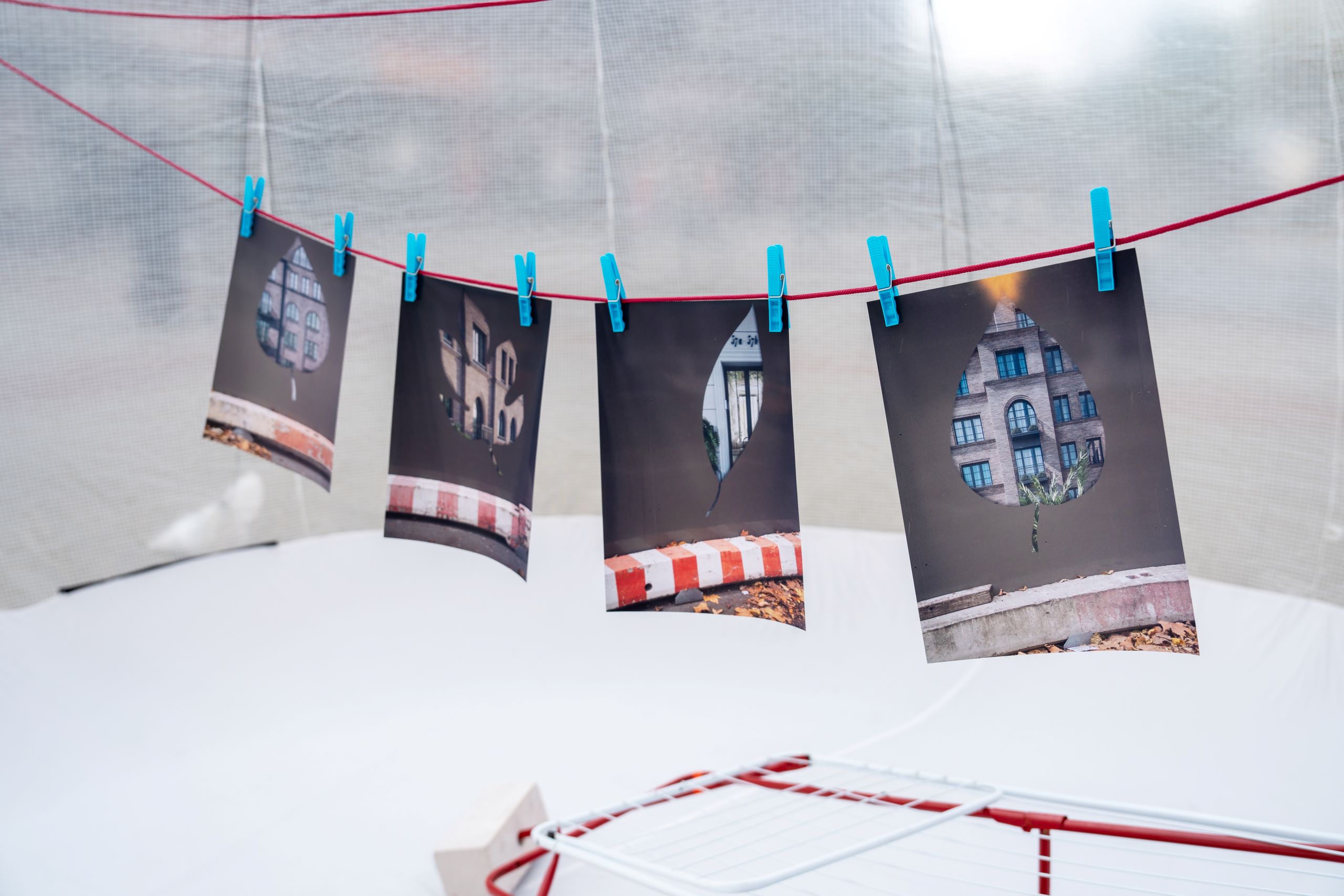 Installation "Immobilienblase" von Anton Steenbock mit Fotografien, Besen und Wäscheständer